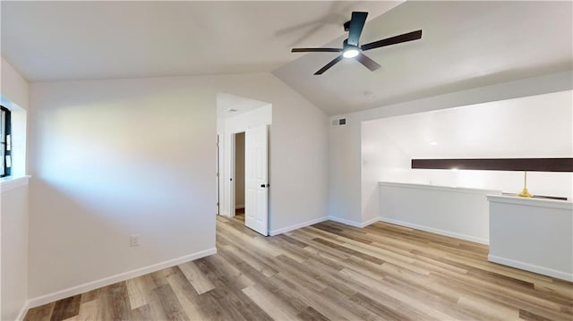 unfurnished room with ceiling fan, wood finished floors, visible vents, baseboards, and vaulted ceiling