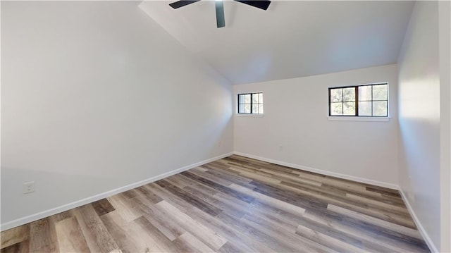 unfurnished room with lofted ceiling, ceiling fan, baseboards, and wood finished floors