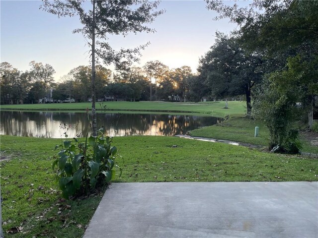 surrounding community with a yard and a water view