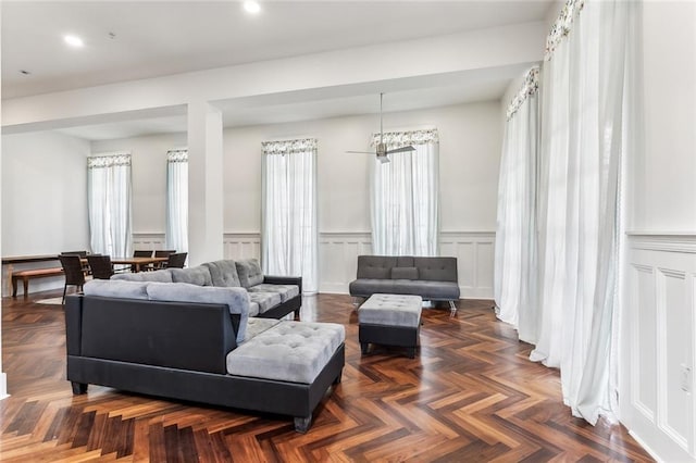 living room featuring recessed lighting, wainscoting, and a decorative wall