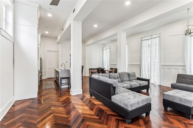 living area featuring a decorative wall, wainscoting, visible vents, and recessed lighting