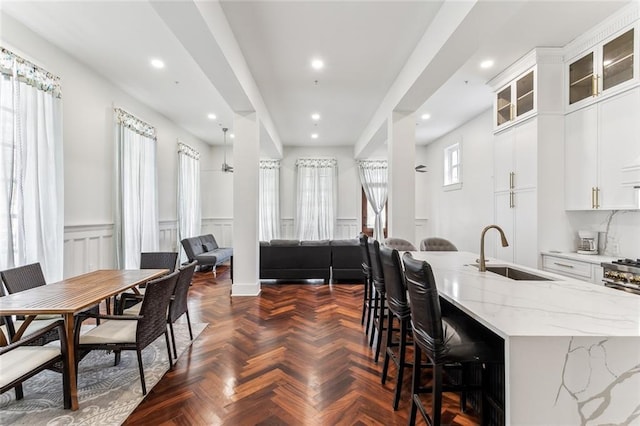 interior space with a wainscoted wall, a decorative wall, and recessed lighting