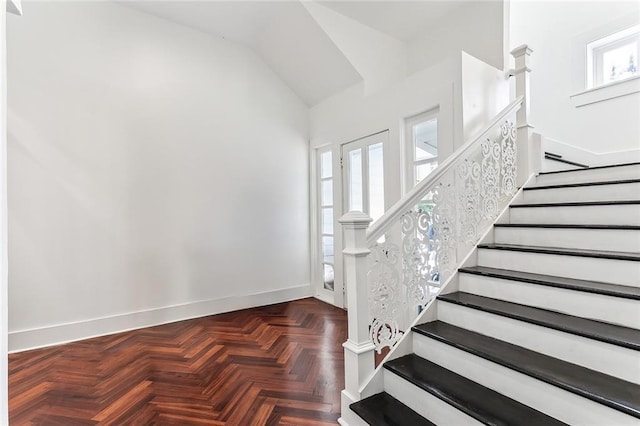 stairs with vaulted ceiling and baseboards