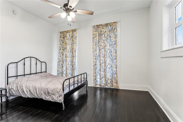 bedroom with a ceiling fan, baseboards, and wood finished floors