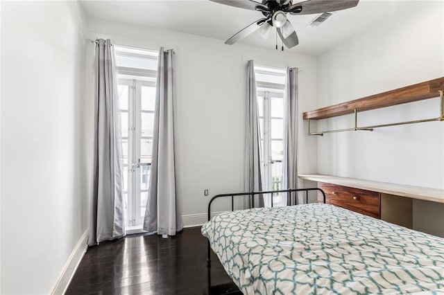 bedroom featuring baseboards, multiple windows, visible vents, and dark wood finished floors