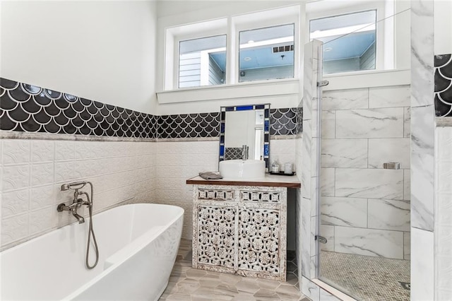 full bath with a freestanding tub, wainscoting, tile walls, and a stall shower