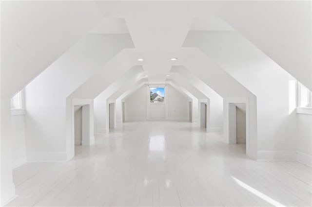 additional living space with lofted ceiling and baseboards