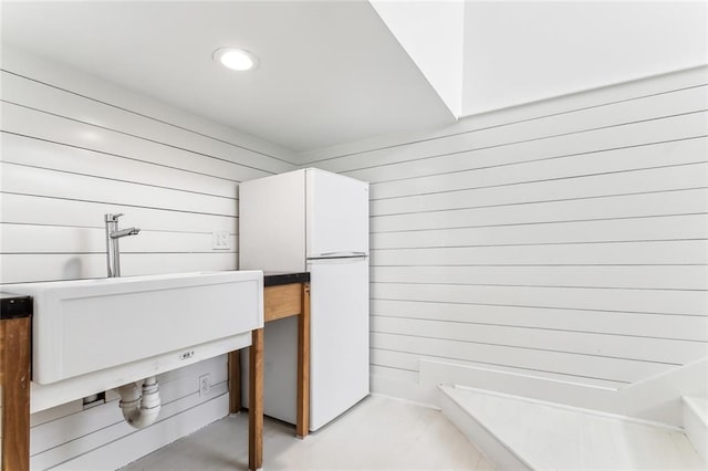 interior space with a sink, freestanding refrigerator, and recessed lighting