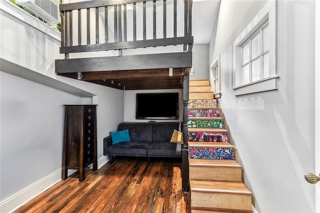 staircase featuring wood finished floors and baseboards