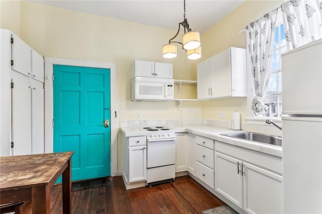 kitchen featuring white appliances, white cabinets, light countertops, and decorative light fixtures