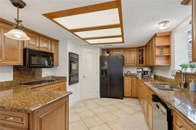 kitchen featuring decorative light fixtures, a sink, brown cabinets, black appliances, and glass insert cabinets