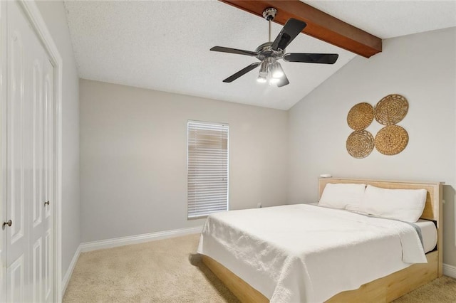 bedroom with a closet, light carpet, lofted ceiling with beams, and baseboards