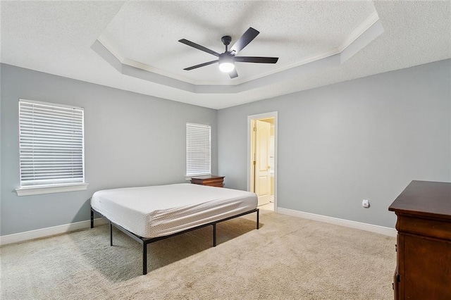 bedroom featuring baseboards, a raised ceiling, a ceiling fan, light colored carpet, and a textured ceiling