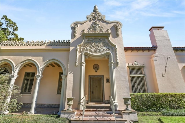 exterior space featuring a tile roof, a chimney, and stucco siding