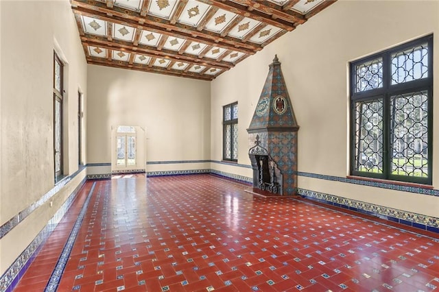 unfurnished living room with a baseboard radiator, a high ceiling, a fireplace, and baseboards