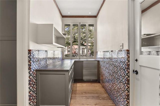 bar with light wood-style flooring and crown molding