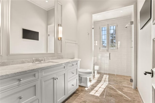 bathroom featuring toilet, ornamental molding, a stall shower, vanity, and baseboards