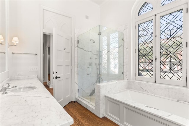 full bath with a garden tub, a marble finish shower, wood finished floors, and vanity