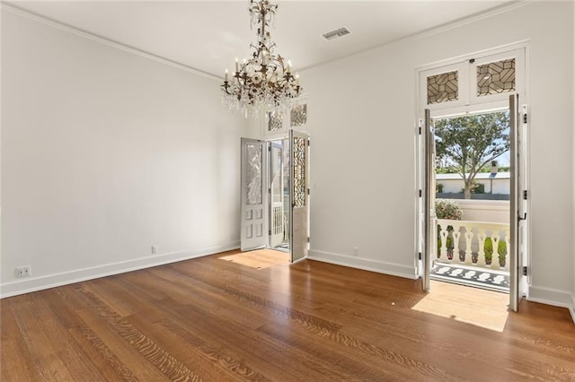 unfurnished dining area featuring crown molding, wood finished floors, visible vents, and baseboards