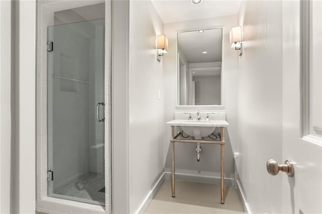 full bathroom featuring a stall shower, vanity, and baseboards