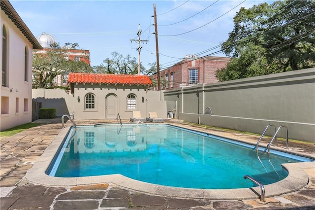 view of pool featuring a fenced in pool, a fenced backyard, a patio, and an outdoor structure