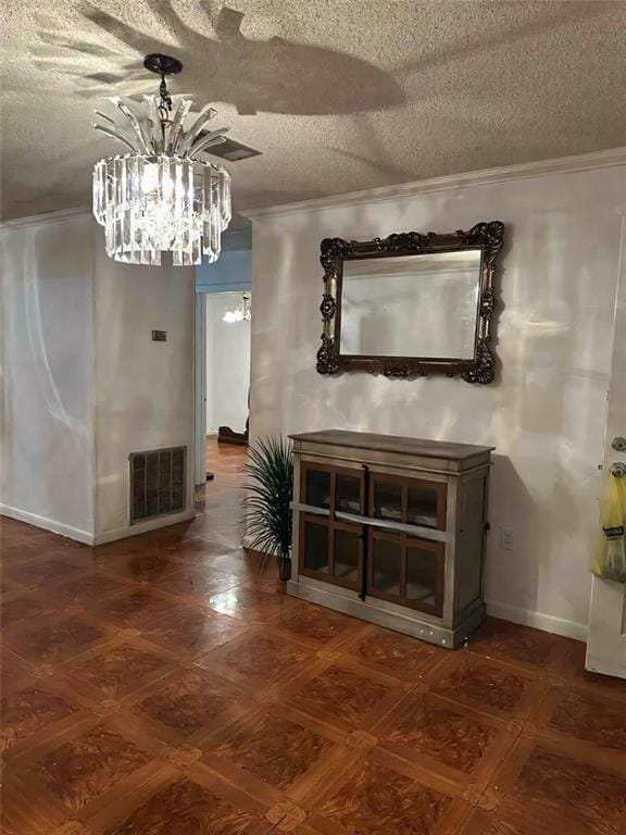 interior space featuring baseboards, visible vents, ornamental molding, a textured ceiling, and a chandelier