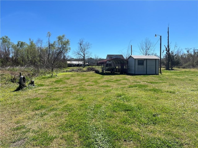 view of yard with a carport and an outdoor structure