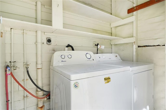 washroom featuring concrete block wall, laundry area, and washing machine and clothes dryer