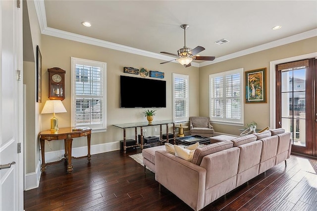 living area with crown molding, visible vents, dark wood finished floors, and a wealth of natural light