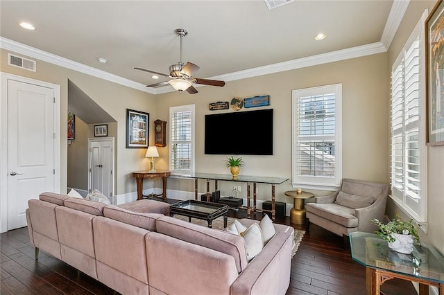 living room with dark wood-style floors, a healthy amount of sunlight, and ornamental molding