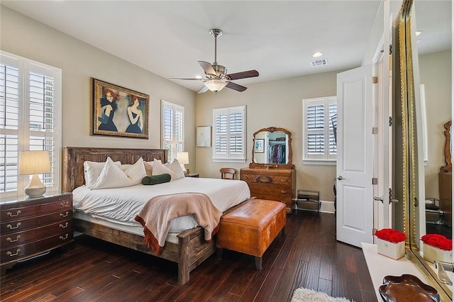 bedroom with dark wood-style floors, baseboards, visible vents, and a ceiling fan