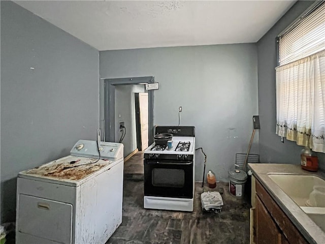 kitchen featuring a sink, range with gas cooktop, and washer / dryer