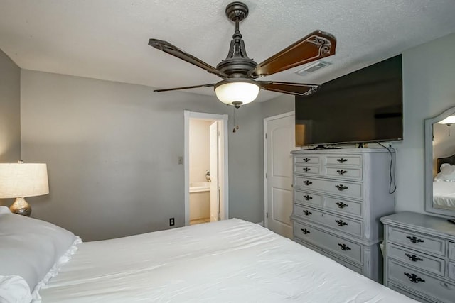 bedroom featuring ceiling fan, visible vents, and a textured ceiling