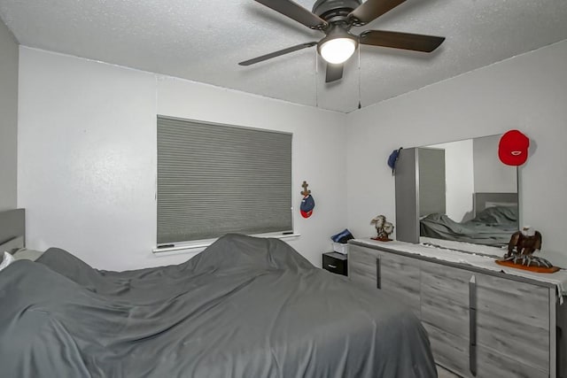 bedroom with a ceiling fan and a textured ceiling