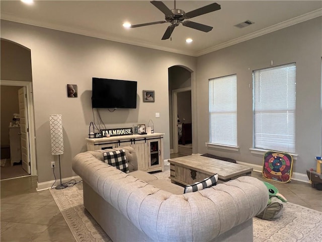 living room featuring visible vents, arched walkways, baseboards, ornamental molding, and recessed lighting