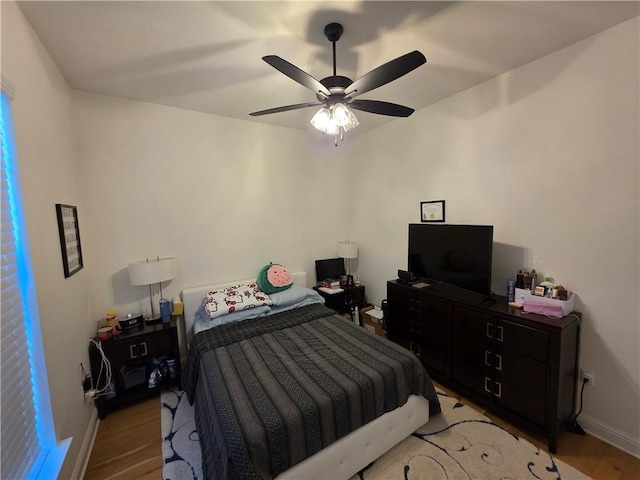bedroom featuring light wood-style floors, baseboards, and ceiling fan