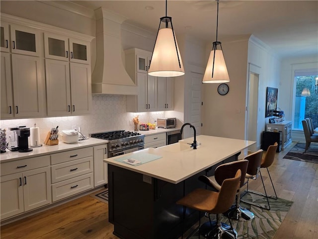kitchen with crown molding, premium range hood, dark wood-style flooring, and high end stove