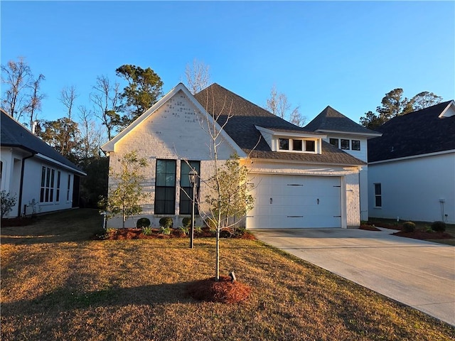 view of front of home featuring driveway, an attached garage, and a shingled roof