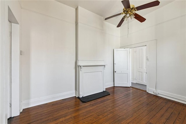 spare room featuring ceiling fan, baseboards, and dark wood-style flooring