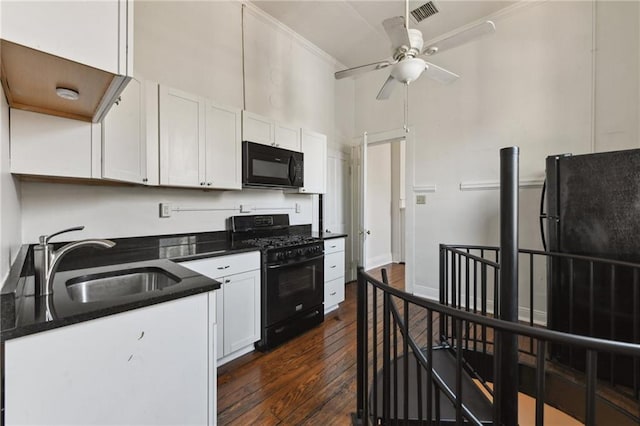 kitchen with black appliances, white cabinetry, visible vents, and a sink