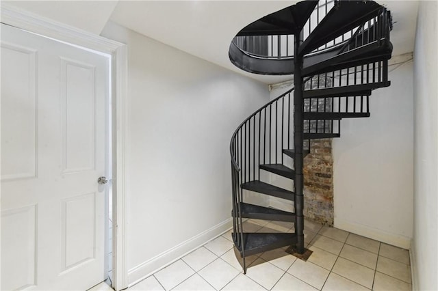 staircase featuring tile patterned flooring and baseboards