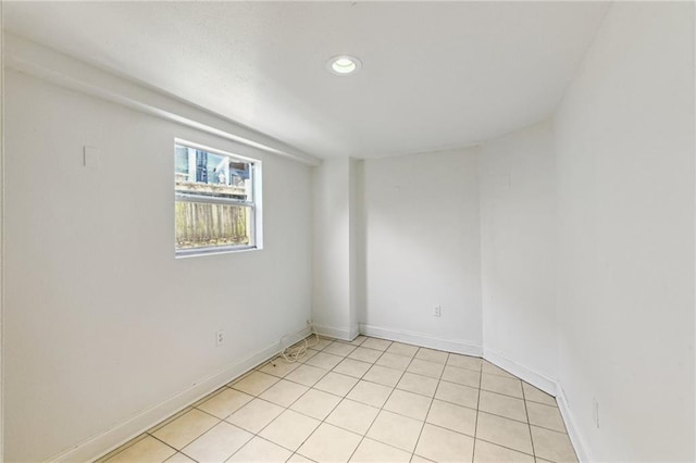 spare room featuring recessed lighting and baseboards