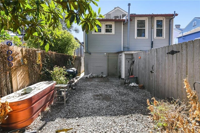 back of house with a fenced backyard