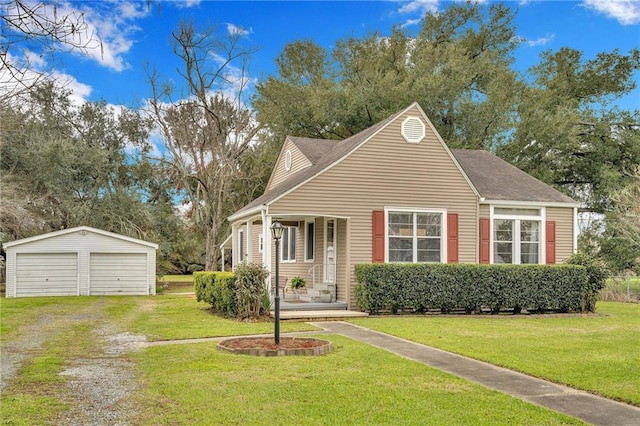 view of front of house with driveway, an outdoor structure, a detached garage, and a front yard