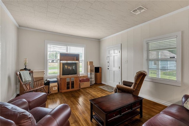 living area with a wealth of natural light, ornamental molding, wood finished floors, and visible vents