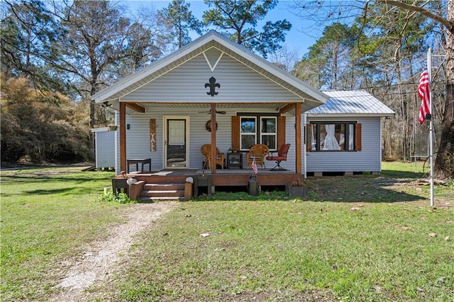 bungalow with a front yard, covered porch, and metal roof