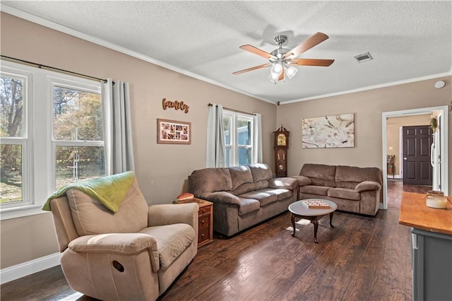 living room with a textured ceiling, ornamental molding, dark wood finished floors, and visible vents