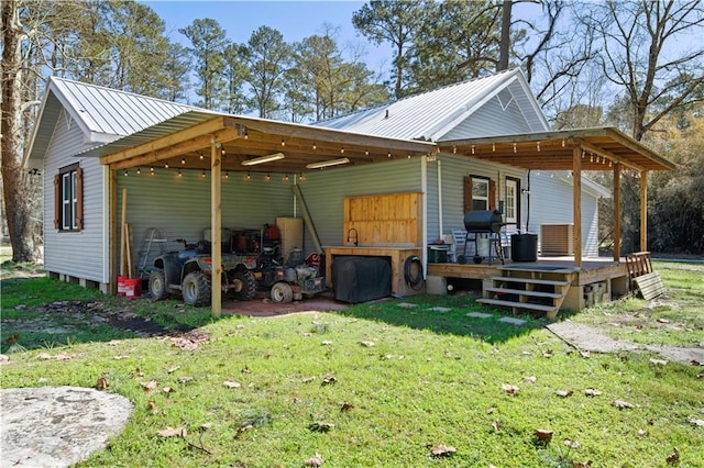 exterior space with metal roof, a carport, and a yard