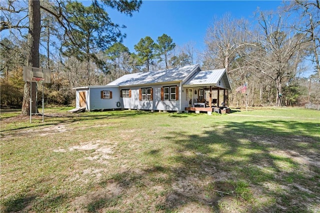 view of front of house featuring metal roof and a front lawn