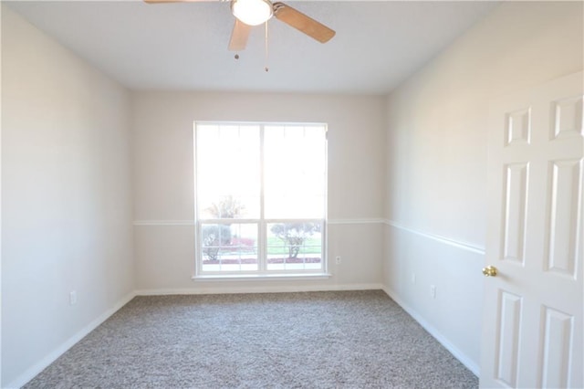 empty room with carpet floors, baseboards, and a ceiling fan